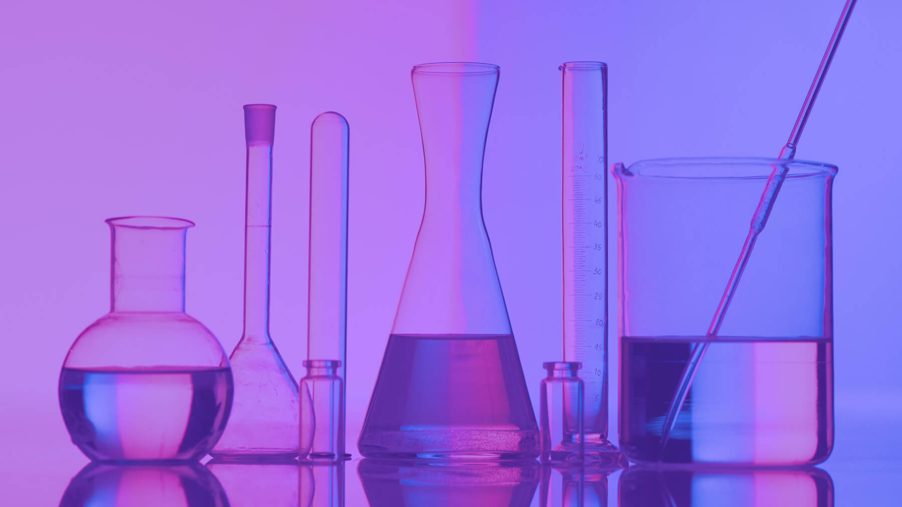 Image of lab beakers and fluid depicting a science environment.